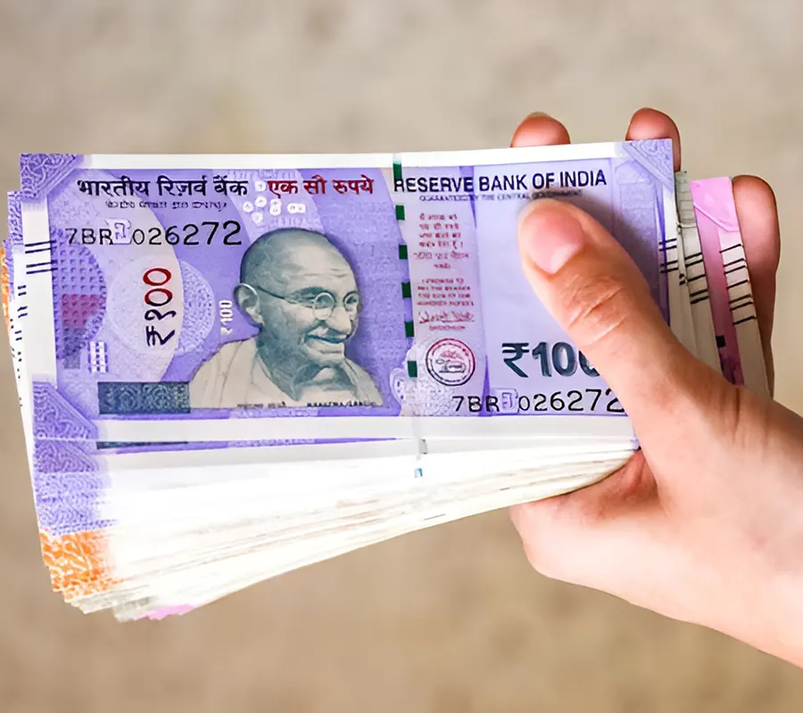purple Indian rupee notes in hand
