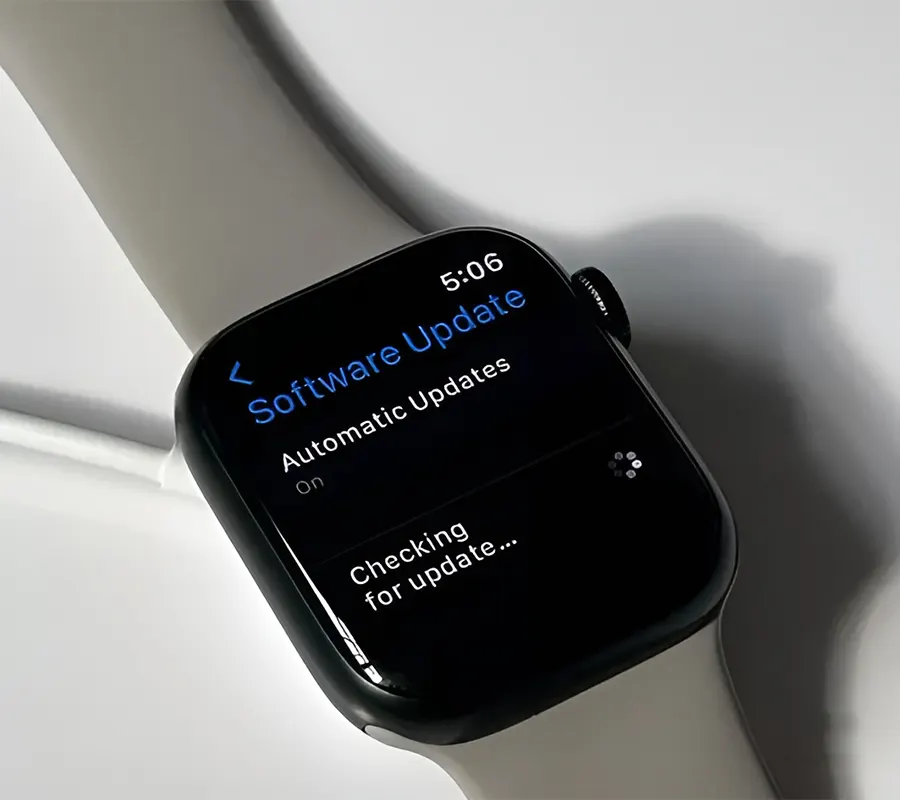 An iWatch with grey-colored bands showing "checking for updates" on screen